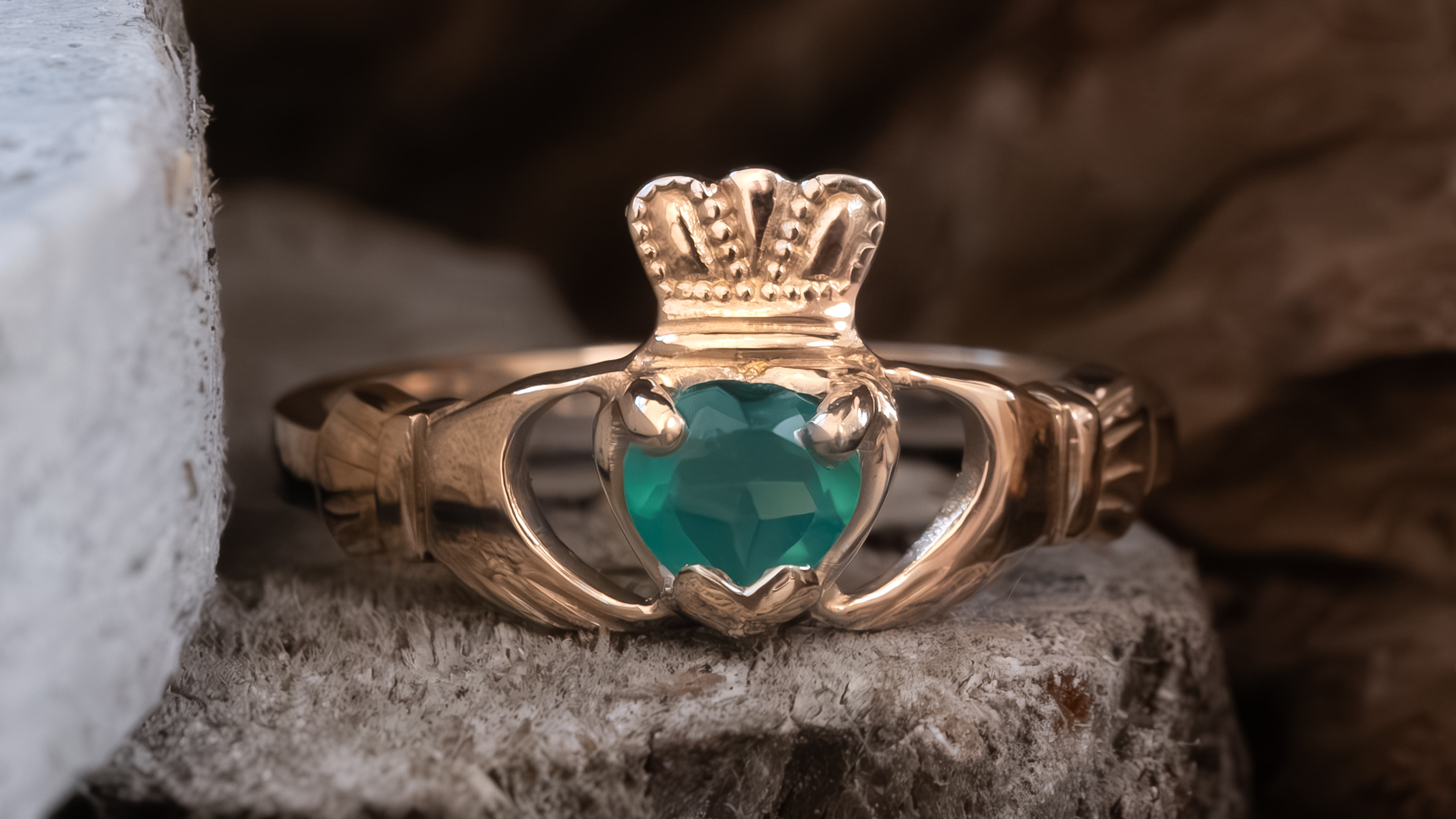 Claddagh ring with a faceted gemstone set in the heart, showing birthstone placement