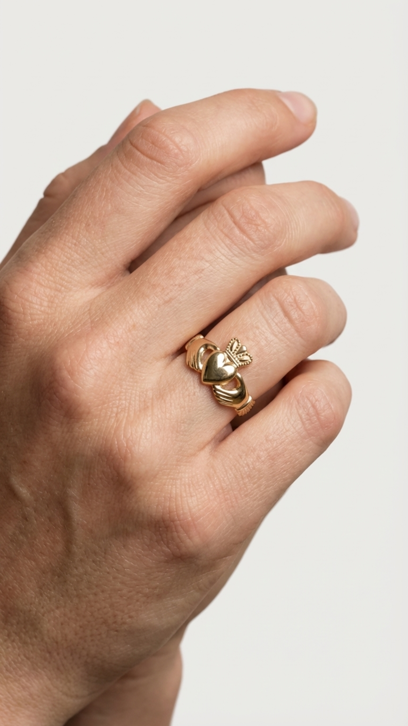 Claddagh ring worn on the hand showing how the design is worn in daily life